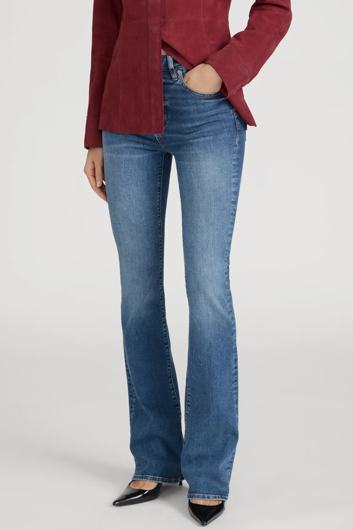 Person wearing blue jeans and a red blazer on a white background