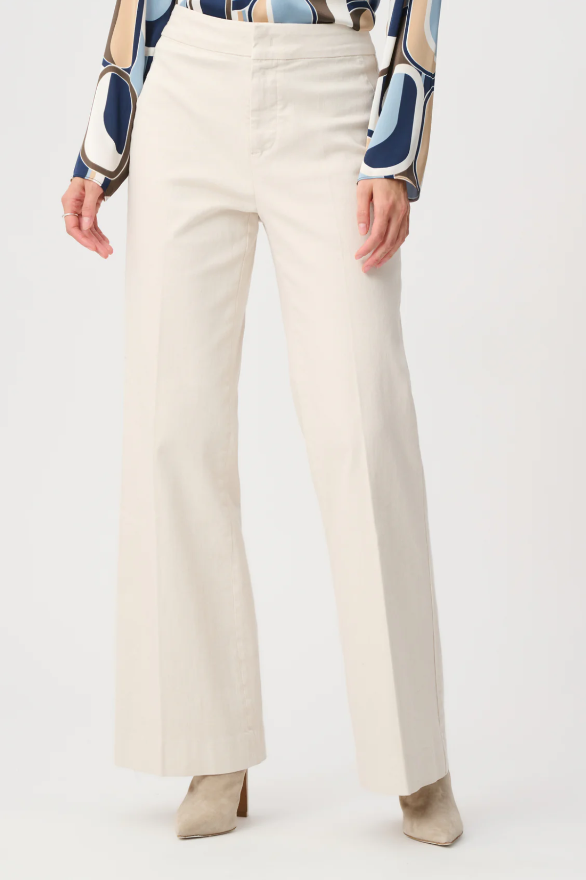 Model wearing white high-rise stretch denim wide-leg jeans with a full-length silhouette.