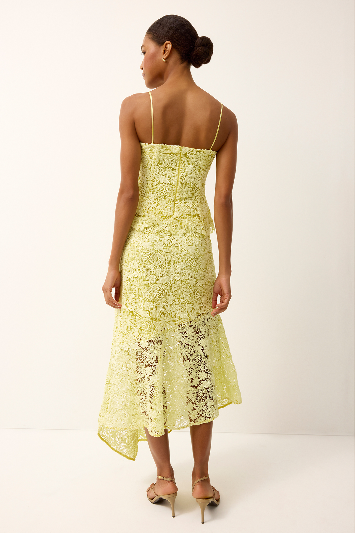 Woman wearing a yellow lace set on a white background