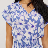 Woman wearing a blue floral dress against a white background