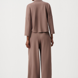 Person wearing a brown suit on a white background