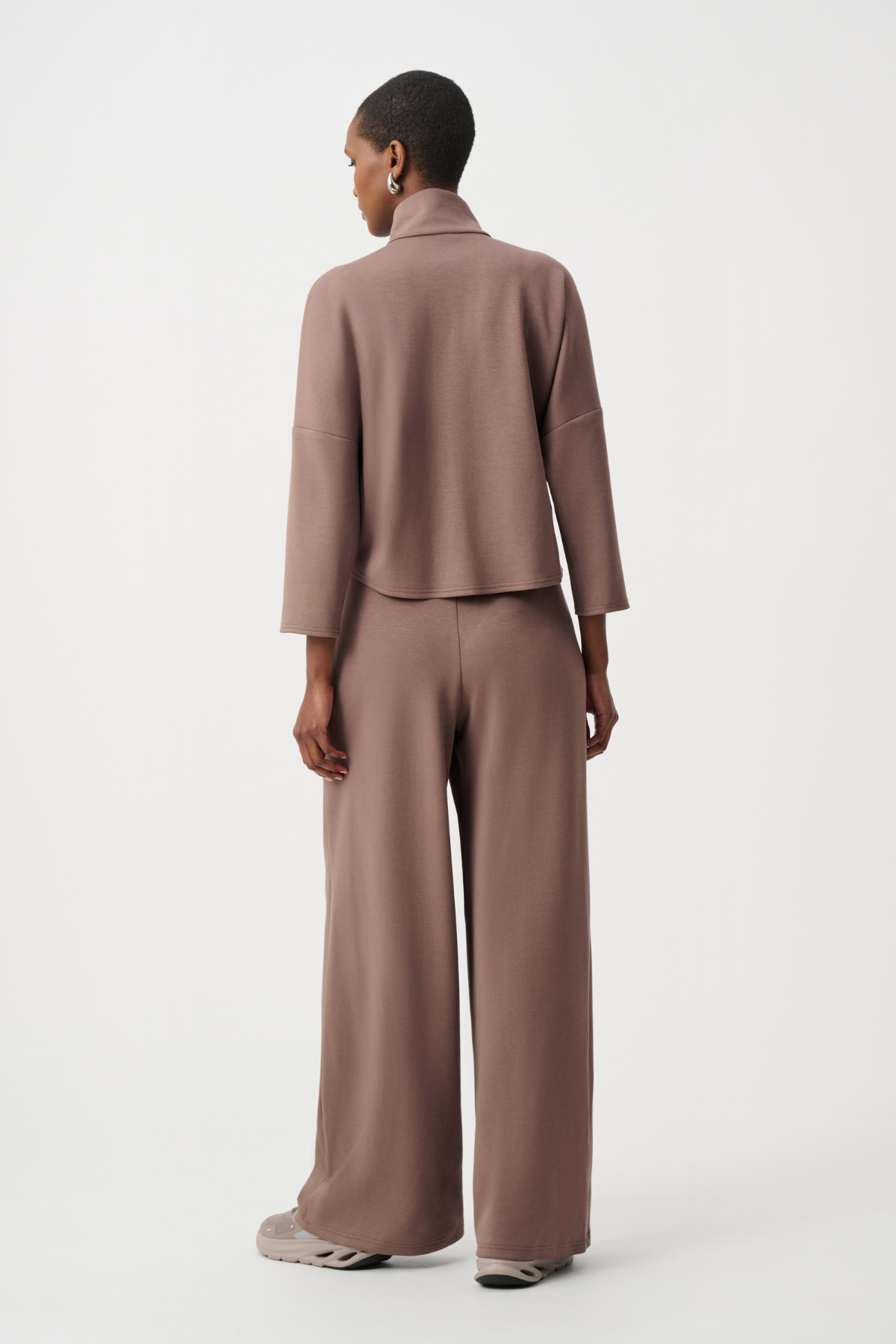 Person wearing a brown suit on a white background