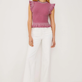 Woman wearing a red and white striped top with white pants on a white background