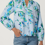Woman wearing a floral blouse with blue jeans on a white background