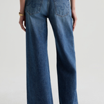Model wearing high-rise wide-leg denim pants with a relaxed, full-length silhouette.