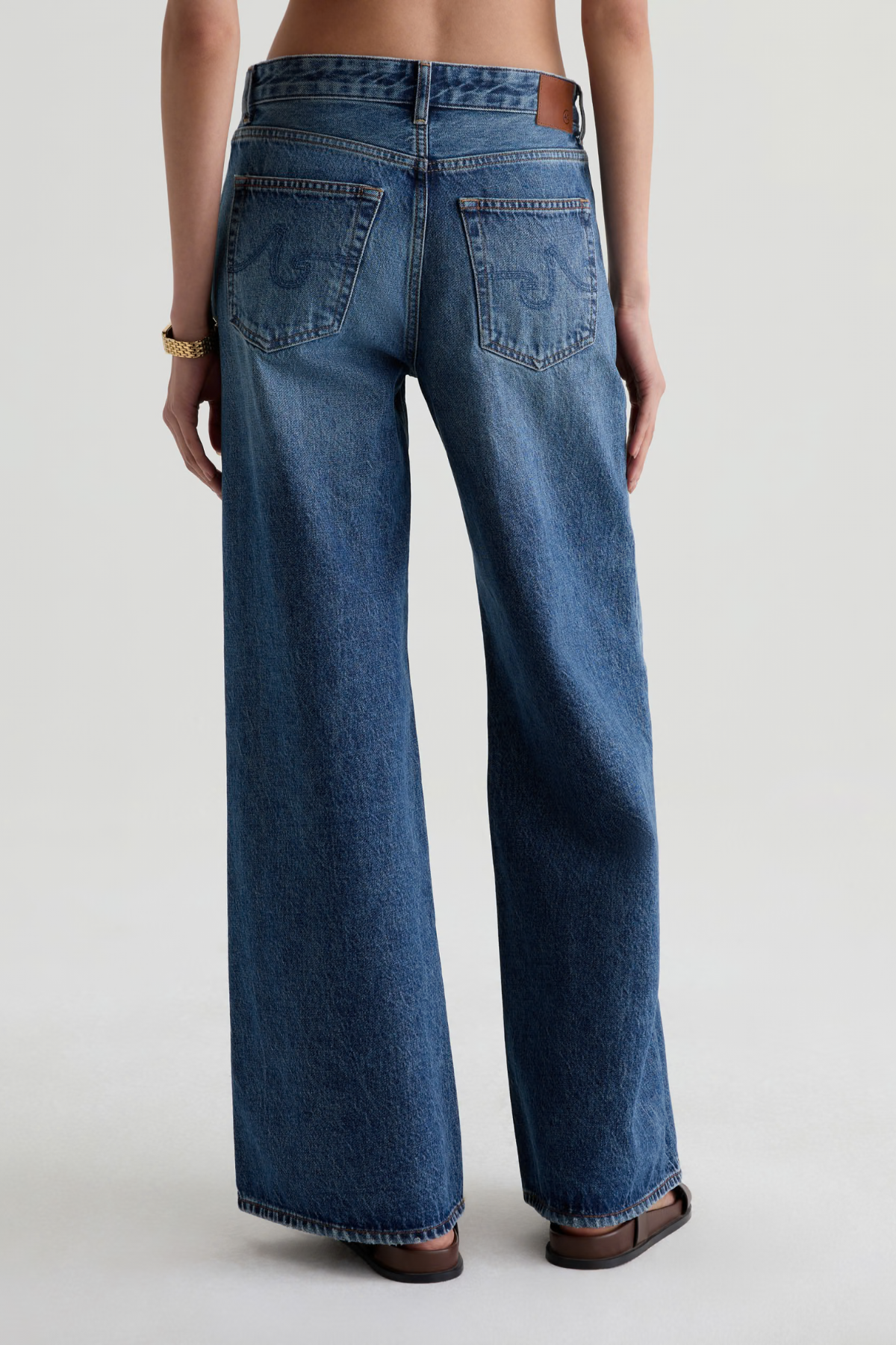 Model wearing high-rise wide-leg denim pants with a relaxed, full-length silhouette.