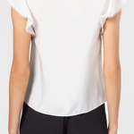 White blouse with lace trim and black shorts on a plain background