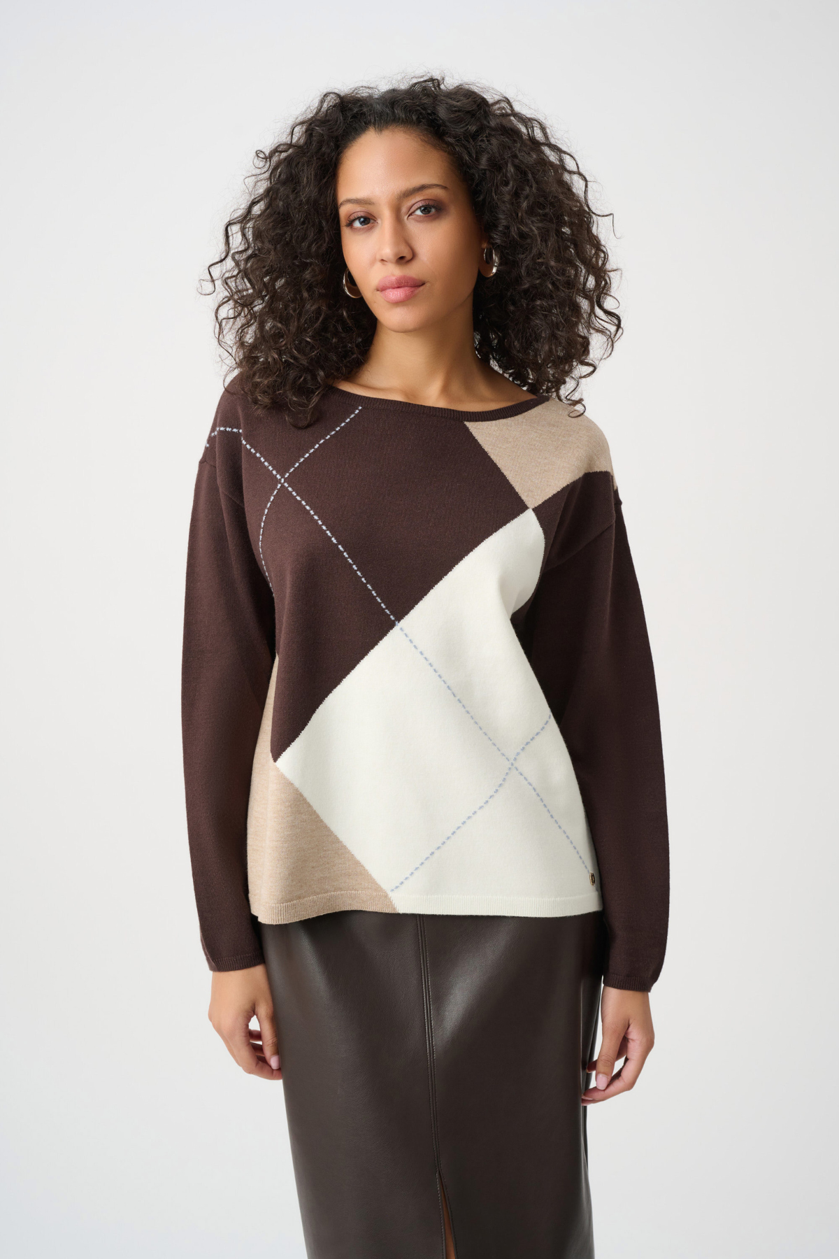 Woman wearing a brown, beige, and white patterned sweater on a white background