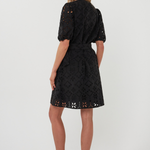 back of woman in black mini dress on white background 