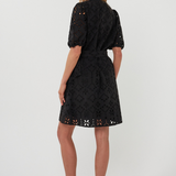 back of woman in black mini dress on white background 