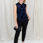 Woman wearing black chino trousers with a front hem split, styled with heels.