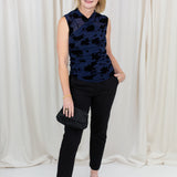 Woman wearing black chino trousers with a front hem split, styled with heels.