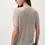 Woman wearing a beige short-sleeve sweater on a white background