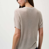Woman wearing a beige short-sleeve sweater on a white background