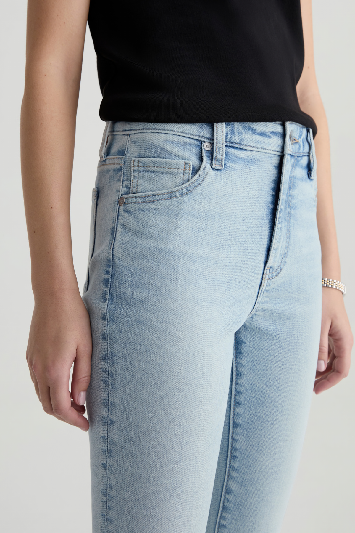 Light blue jeans worn by a person on a plain background