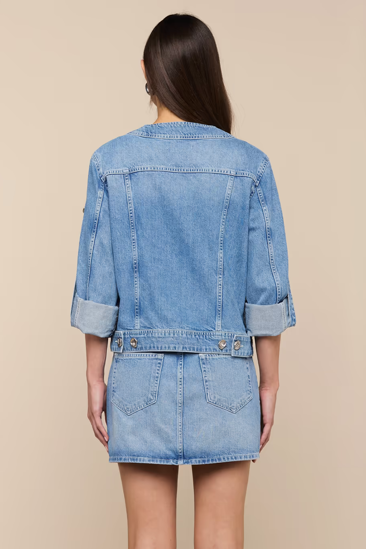 Denim jacket and skirt set on a beige background