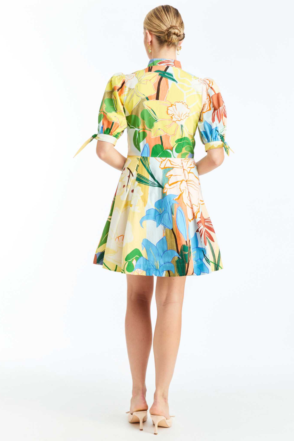 Woman wearing a colorful floral dress on a white background