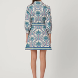 Woman wearing a patterned dress on a white background back view