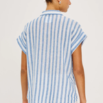 back of woman in blue and white stripe shirt on white background 