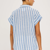 back of woman in blue and white stripe shirt on white background 