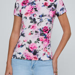 Person wearing a floral t-shirt with pink roses on a plain background