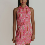 Young girl wearing a pink floral dress against a plain background