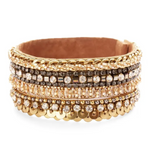 A wide gold-tone cuff bracelet featuring multiple rows of rhinestones, sequins, and metallic details, displayed on a clean white background.