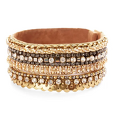 A wide gold-tone cuff bracelet featuring multiple rows of rhinestones, sequins, and metallic details, displayed on a clean white background.