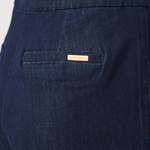 Close-up of dark blue pants with a brand label on the pocket.