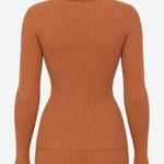 A ribbed knit long-sleeve top in a warm rust or terracotta color, shown from the back on a light gray background.