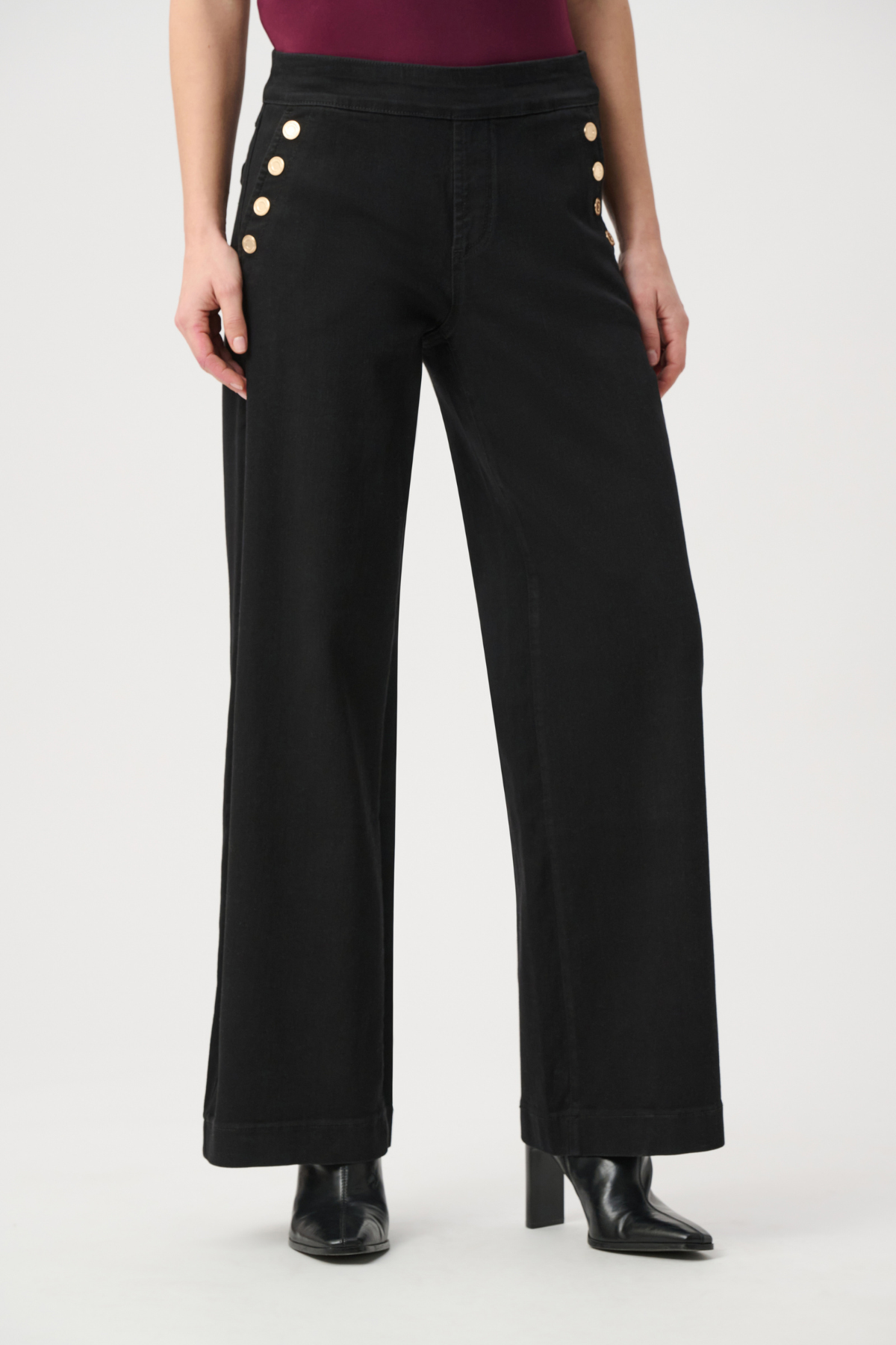 Model wearing dark-wash wide-leg jeans with sailor-inspired button detailing at the waist.
