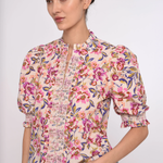 Woman wearing a floral blouse with a plain background