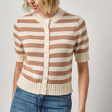 Woman wearing a striped sweater and jeans on a plain background