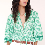 woman in green printed top on white background 