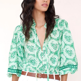 woman in green printed top on white background 