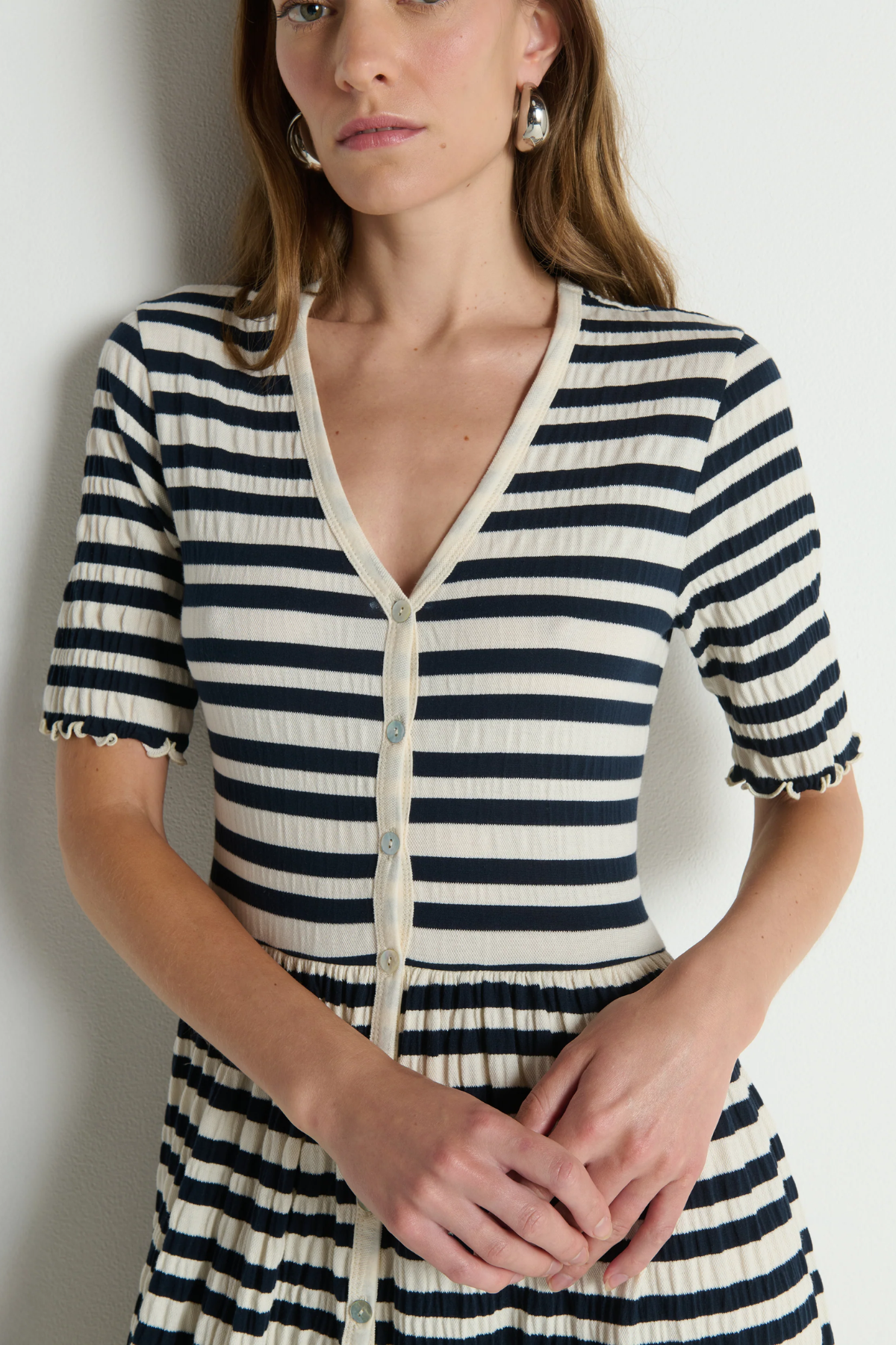Woman wearing a black and white striped dress against a plain background