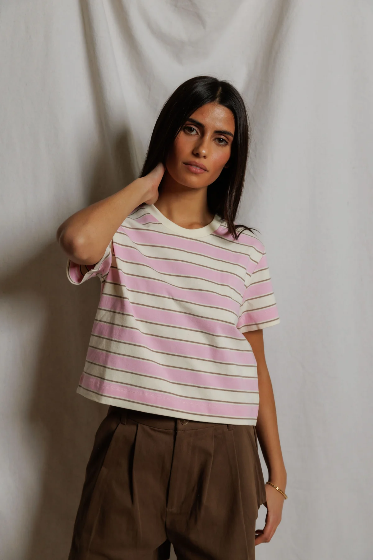Woman wearing a striped shirt against a plain background