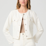 Woman wearing a white denim jacket and shorts on a plain background