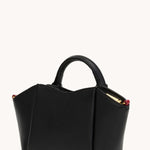 Black Hammitt Paul Mini crossbody bag worn with an evening outfit.