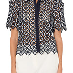 Woman wearing a patterned blouse with a white background