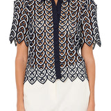 Woman wearing a patterned blouse with a white background