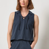 Woman wearing a navy sleeveless top and pants against a plain background