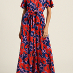 Woman wearing a red and blue patterned dress on a beige background