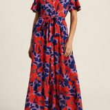 Woman wearing a red and blue patterned dress on a beige background