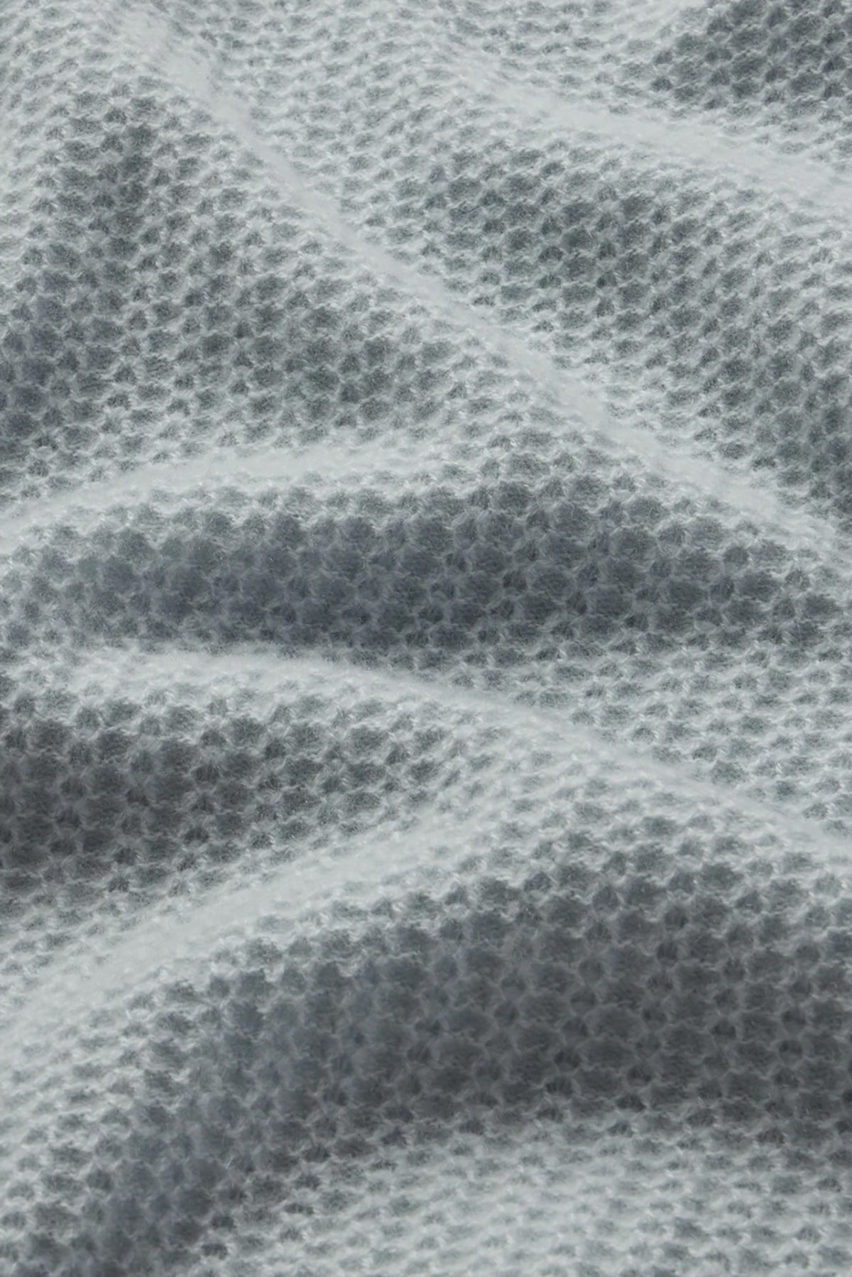 Lightweight pointelle knit sweater with a relaxed silhouette, styled with denim.