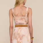 Woman wearing a long, patterned dress with a beige background