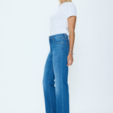 Woman wearing blue jeans and a white top on a white background