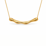 A gold wavy bar necklace on a delicate gold chain, presented against a clean white background.