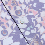 Close-up of a shirt with a butterfly pattern and buttons on a purple background