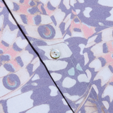 Close-up of a shirt with a butterfly pattern and buttons on a purple background